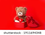 teddy bear and  heart shaped  in box on red background valentine's day, a soft bear toy holds a heart on a white background