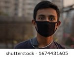 Young sick boy wears a black safety mask.Mask prevents corona virus and air pollution dust.New type coronavirus 2019-nCoV pneumonia in Wuhan has been spreading into many Countries.Man wearing mask