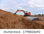 Small photo of Excavator dig the trenches at a construction site. Trench for laying external sewer pipes. Sewage drainage system for a multi-story building. Civil infrastructure pipe, water lines and sanitary storm
