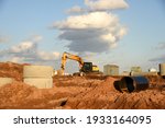 Small photo of Excavator dig the trenches at a construction site. Trench for laying external sewer pipes. Sewage drainage system for a multi-story building. Digging the pit foundation.