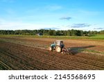 Small photo of Tactor with disk harrow on plowing field. Cultivated land and soil tillage. Tractor with disc cultivator on land cultivating. Agricultural tractor on soil cultivation field. Plough plowed.
