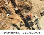 Small photo of Sewage drainage system mounting at construction site. Excavator during laying sewer pipe and main systems. Civil infrastructure, water lines, sanitary sewers and storm sewers. Laying sewer pipes.