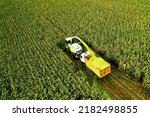Small photo of Corn Harvest. Forage harvester on maize cutting in field. Harvesting crop in farm field. Self-propelled Harvester for agriculture. Tractor on corn harvest. Aerial View Of A Farmer Harvesting Silage.