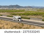 Campervan drive on highway. Family camper van driving on motorway. Motorhome lifestyle travel to sea and mountains. Travel along Spain coast. Traffic cars on road.