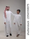 Small photo of A father with his son walking on a white background