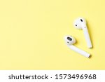 Wireless headphones on a yellow background with place for text.