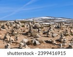 Small photo of A serene view of hand-crafted stone pyramids by visitors, symbolizing the Arctic Circle, near the Arctic Circle Center in Rana, Nordland, Norway
