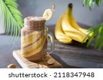 Small photo of Chocolate banana coconut hazelnut milkshake or smoothie. Healthy organic drink. Banana chocolate smoothie, cocktail in a glass jar. Side view, copy space for text. Vegan menu, bar, recipe.