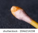 Small photo of Earwax on a cotton swab, macro photo. Earwax, also known by the medical term cerumen, is a brown, orange, red, yellowish or gray waxy substance secreted in the ear canal of humans and other mammals.