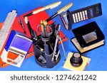 Small photo of Office stationery - products and accessories used for correspondence and processing of paper documents. In office work popular calculator pen pencil print scissors sticker paperclip stapler folder rul