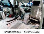 Interior of new luxury car prepared for valentine's day romantic dinner. Champagne and gift waiting in wood and white leather interior.