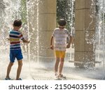 Small photo of Boy having fun in water fountains. Child playing with a city fountain on hot summer day. Happy kids having fun in fountain. Summer weather. Active leisure, lifestyle and vacation.