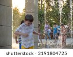 Small photo of Boys jumping in water fountains. Children playing with a city fountain on hot summer day. Happy friends having fun in fountain. Summer weather. Friendship, lifestyle and vacation.