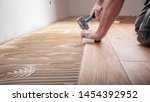 Craftsman lays parquet floor...