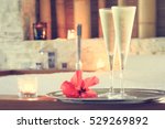 Two glasses of champagne with candle and red flower near jacuzzi. Valentines background. Romance concept. Horizontal, toned
