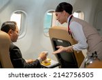Small photo of Air hostess or cabin crew serve dessert and cake to business man and also ask for the problem during flight to other country.