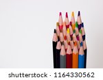 Small photo of Assorted color map coloring pencils framed lower right on solid background