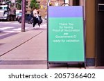 Small photo of Thank you for having proof of vaccination and government ID ready for validation in front of a restaurant agains blurred city street.Proof of COVID-19 vaccination will be required to access businesses