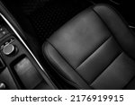 Top view of luxury sport car front passenger leather seat with detail high end fabric and stitch texture along with blurred control button panel. Design element and black car interior background.