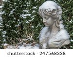 Small photo of Chinese mass production Polyresin female bust in front of conifer hedge and faded plant covered with snow in a garden Closeup view for book cover, brochure, flyer, magazine, CD design, website