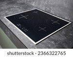 Small photo of Flat cooktop cooking induction electric built black stove. Grey countertop with black glossy built in ceramic tempered glass induction or electric hob stove cooker with four burners in kitchen.