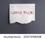 Text on torn note paper identified CONTROL FREAK , concept of person need to be in charge of things and people around, to make sure everything goes their way