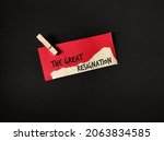 Small photo of Red torn paper clip cloth pin on black background with text written THE GREAT RESIGNATION, concept of transition to post-pandemic workplace, the big quit trend, millions workers leave full time job