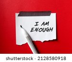 Small photo of Stick note on red background with pen writing text I AM ENOUGH, Positive mantra affirmation self acceptance, Knowing that you are worthy, valid loved. Embrace all flaws and imperfection