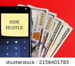 Cash dollar money and mobile with text written note SIDE HUSTLE, concept of make more money or earn more from side business, make extra income from online gig job