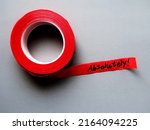 Small photo of Red tape on gray background with handwritten text ABSOLUTELY! means to agree completely - beyond any doubt , totally certain or very clear explanation or without exception