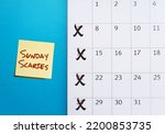 Calendar on blue background crosson Sunday with stick note SUNDAY SCARIES (Sunday blues) - feelings of intense anxiety or dread happen on day before head back to work, office or school 