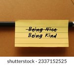 Small photo of Note stick on pencil and office envelope with handwritten text BEING NICE crossed off to BEING KIND, to stop being People Pleaser, prioritize self-respect and start being kind instead