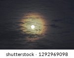 Small photo of Full moon with altocumulus clouds and colorful corona, also called aureole (optical phenomenon).