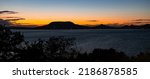 Scenic panoramic view of Lake Balaton in Hungary after sunset. The hills on the other side of the lake stand out sharply against the colorful twilight sky.
