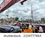 Small photo of Gulbarga, India- September 29th 2021; Stock photo Indian crowded cityscape, few people walking on the road, rickshaw driver waiting for passenger, vehicles moving froward, dark cloud on background.