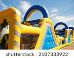 Inflatable obstacle course slide for kid games or team building outdoor activities.
