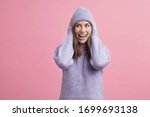 Young fashion woman looking cute with sweater and matching hat on colorful background ready for winter
