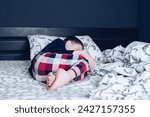 Small photo of Bare feet of a child. A child in pajamas. Bare feet sticking out from under the blankets. The boy is sleeping in bed. Foot and leg