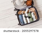 Luggage and suitcase packing for vacation on white wooden background in studio 