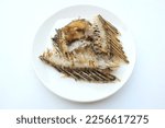 Small photo of fishbone,Bones or Scrap of food in the white plate after eating. Remains of fried fish. food scraps.