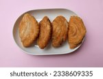 Small photo of deep fried curry puff,curry puff pastry, karipap,epok epok, spiral curry puff isolated a pink pastel backdrop . thai curry puff concept.this pastry is asian traditional snacks