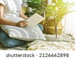Small photo of Woman chilling and reading in living room, Artificial plant, Fiddle leaf fig tree, Indoor tropical natural houseplant for home interior and air purification.