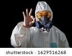 Small photo of Asia woman o.k hand sign in a chemical protective clothing and Woman in chemical protective clothing and half mask replaceable particulate filter respirator with glasses at black background