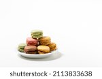 Delicate macaroons or french macarons cakes on white plate on white background.