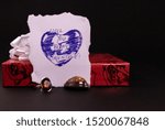 Small photo of Valentine gift concept. Decorated Red gift box and hand wriiten message quote on white paper with cinnamon stone ring on dark background. Ring gift concept