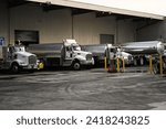 Small photo of Honolulu, HI - December 13, 2023: Gasoline tanker trunks refueling at chevron petroleum industry distribution center loading docks before delivery.