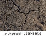 Small photo of Dry cracked sandy soil texture. Flinty ground background with cracks. Top view