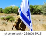 Small photo of Israeli soldier with a large Israel Flag on his shoulder. Concepts photo: Israel Independence Day, IDF, Memorial Day, Jewish soldier