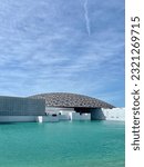 Small photo of Abu Dhabi, UAE - 6 February 2023: The Louvre Abu Dhabi. It construct seemingly floats on water. Outside of The Louvre.