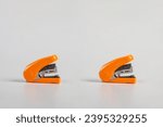 Small photo of Orange stapler, view side stapler on white background.